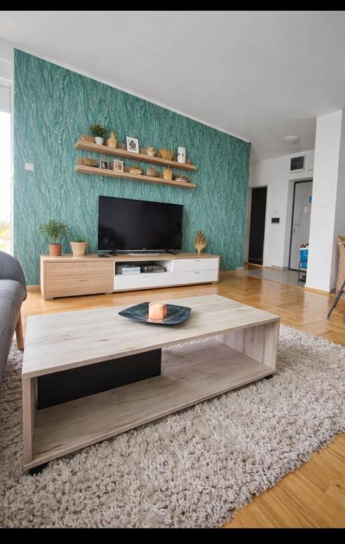 a living room with a tv and a coffee table at Krstić_lux apartman in Subotica