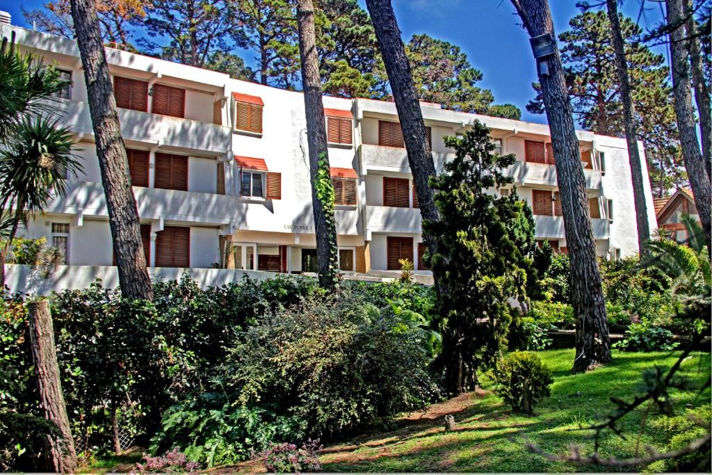 an apartment building with trees in front of it at Dunas I, 3 in Pinamar