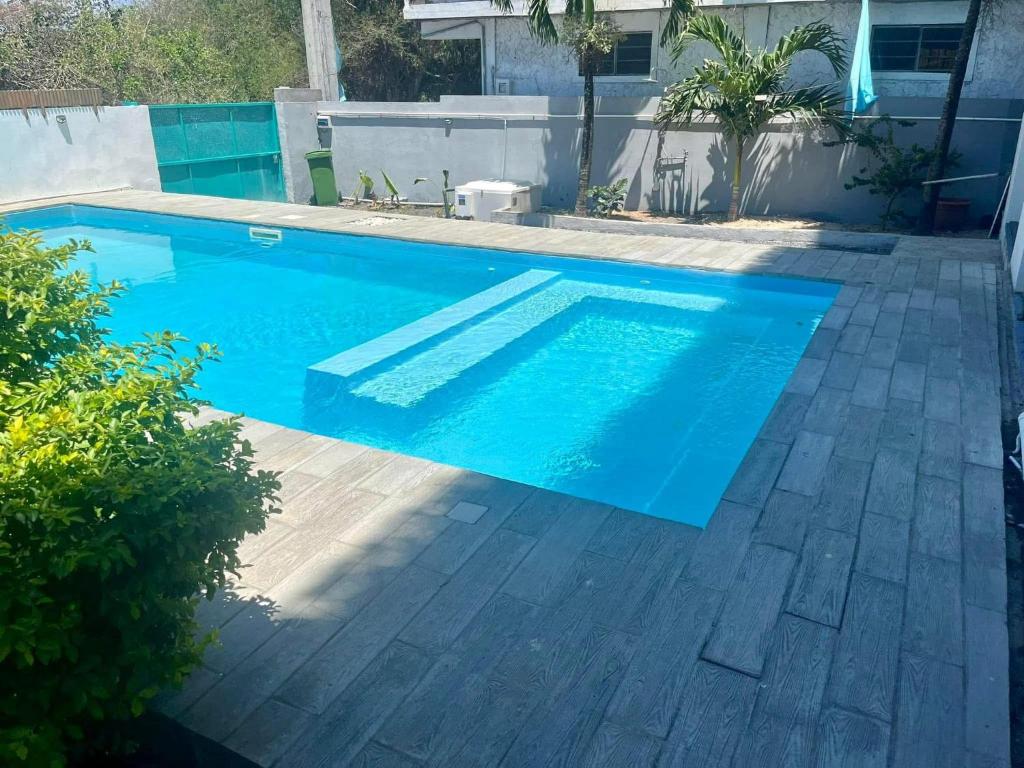 a swimming pool with blue water in a yard at Din villa in Cap Malheureux