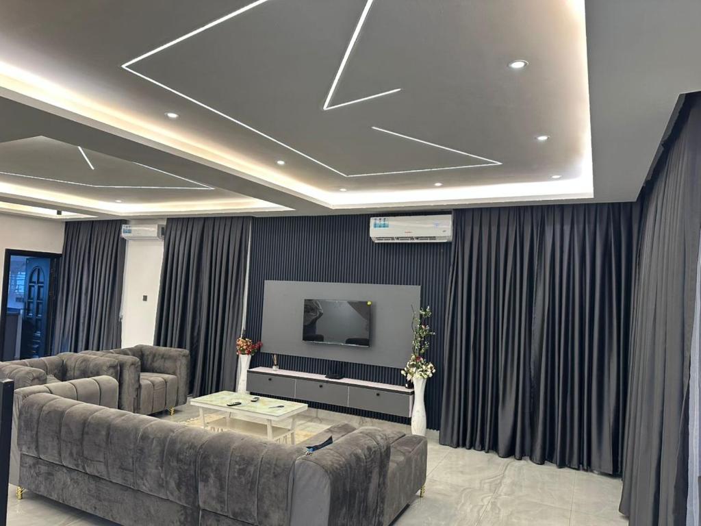 a living room with a couch and a flat screen tv at Happy Home in Trofwi