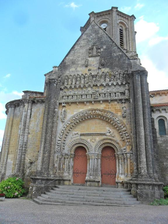 an old church with two red doors and stairs at Chambres d&#39;Hôtes Bienvenue in LʼAbsie