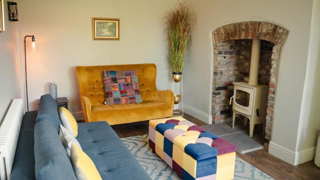 a living room with a couch and a fireplace at 2 Bridge View in Selby