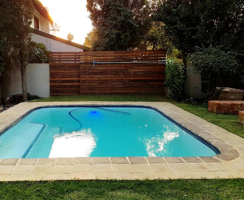 una pequeña piscina azul en un patio en Cottage Guesthouse en Pretoria
