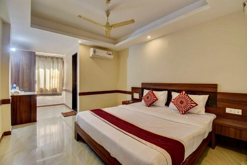 a bedroom with a large bed with red pillows at Sai Arya Residency By The Avyaan in Mangalore