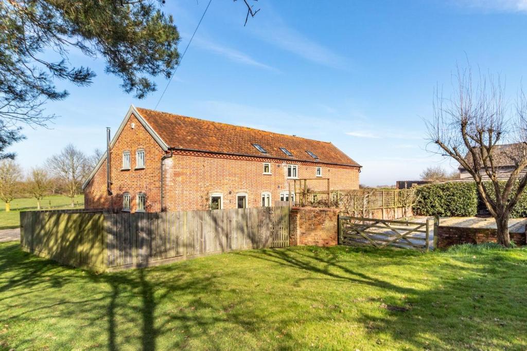a brick house with a fence in a yard at 3 Bed in Knodishall oc-ebco in Aldringham