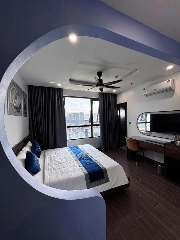 a bedroom with a bed with a ceiling fan at Lâm Luxury Hotel Lào Cai in Chơ Mơi