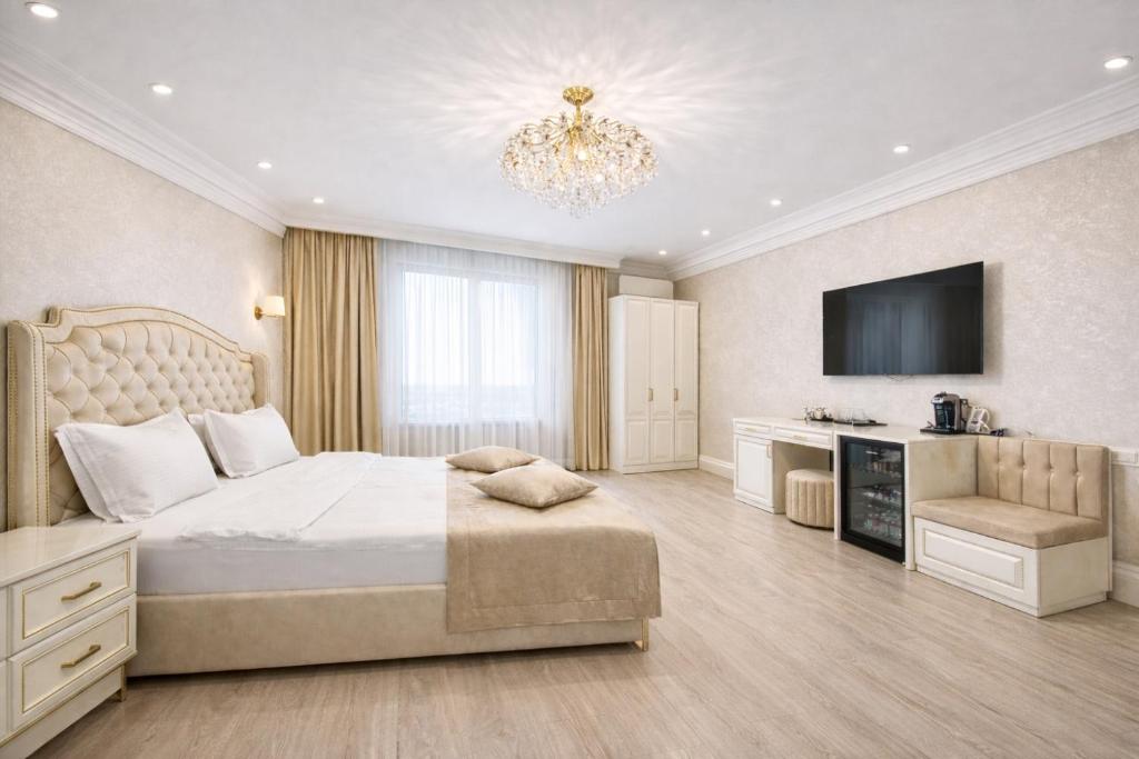 a bedroom with a large bed and a chandelier at Yerevan In Boutique Hotel in Yerevan