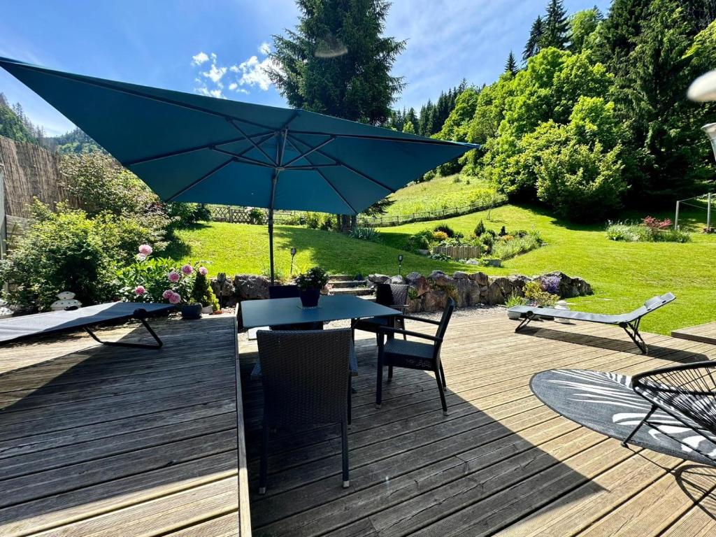 a patio with a table and chairs and an umbrella at L annexe in Saint-Jean-d'Aulps