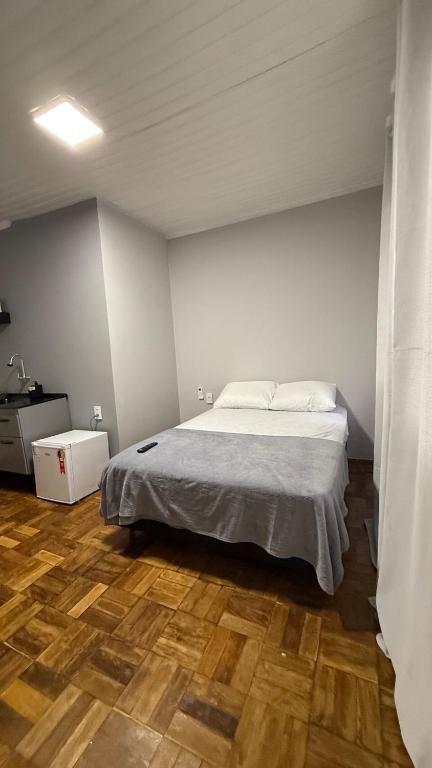 a bedroom with a bed and a wooden floor at Flat em excelente localização de Chapecó in Chapecó