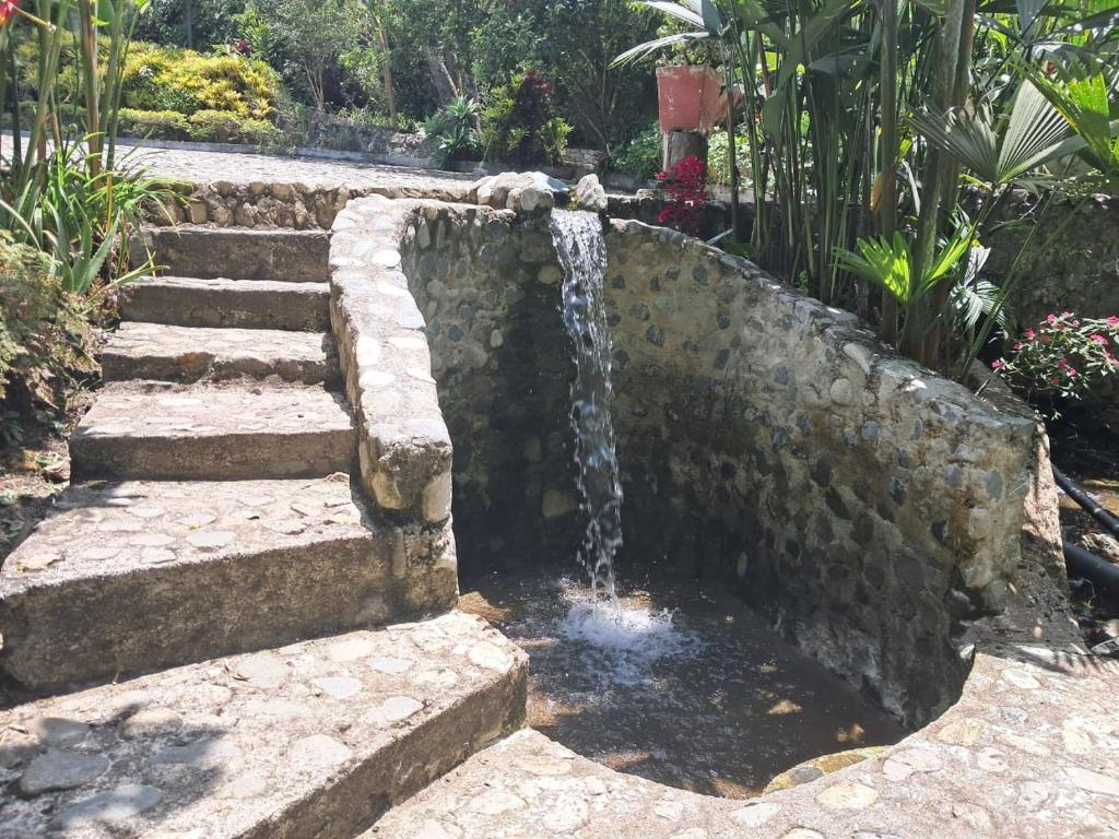 a stone fountain in a garden with stairs at Villa Tahiti in Palmira