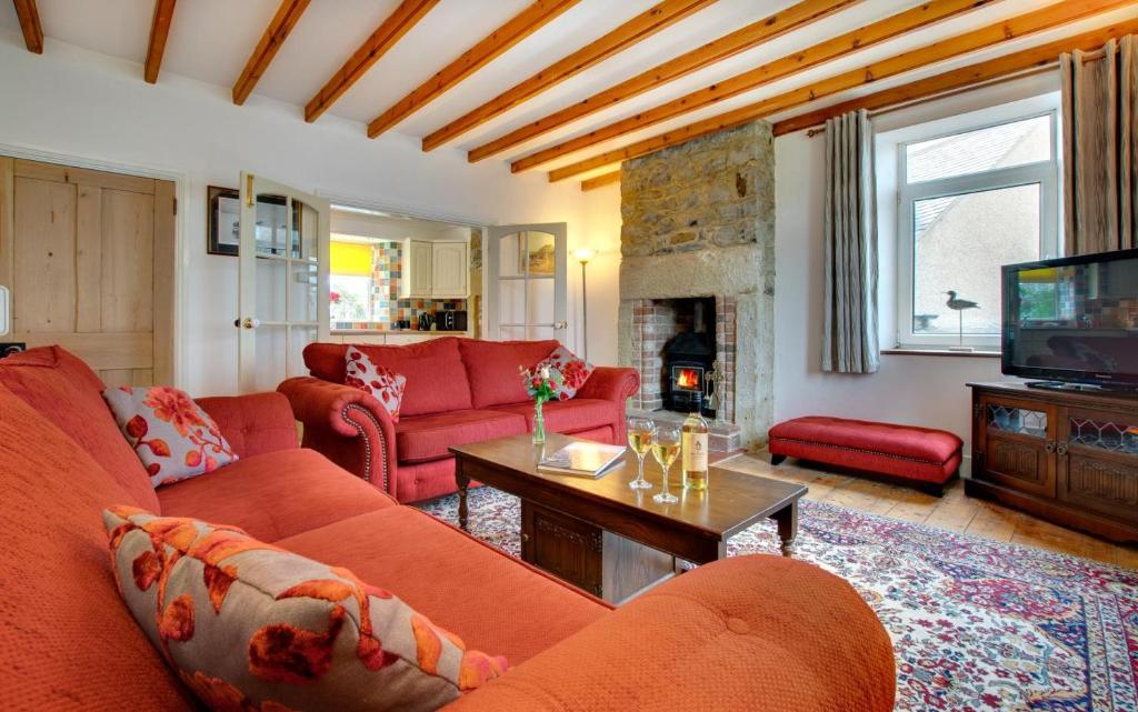 a living room with red couches and a tv at 3 Bed in Craster oc-79891 in Craster