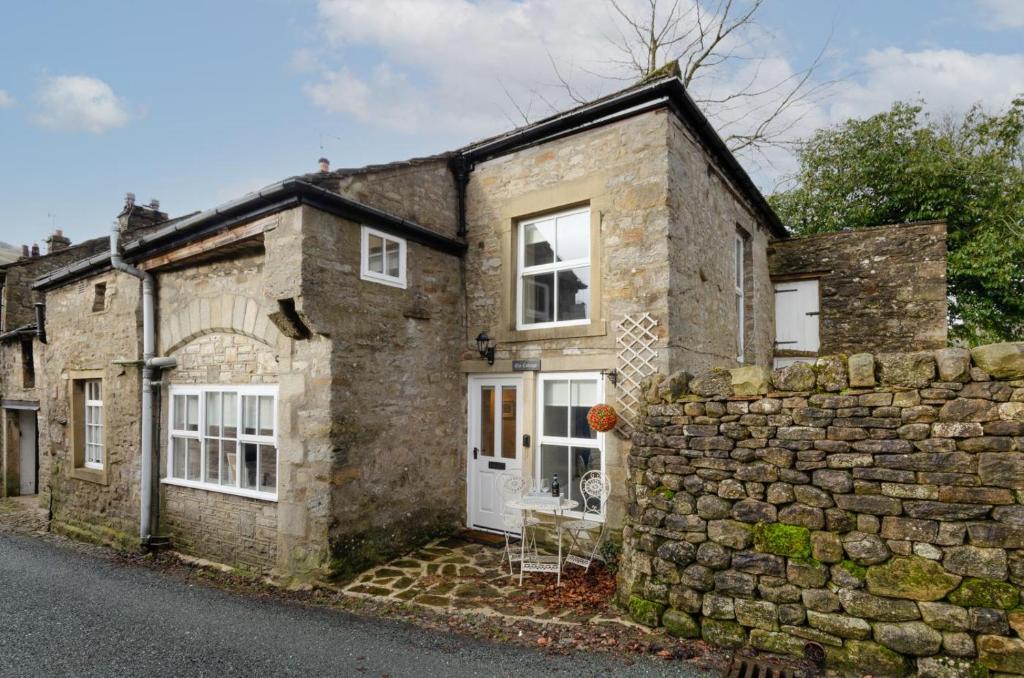 an old stone house with a stone wall at 2 Bed in Kettlewell oc-ds985 in Kettlewell