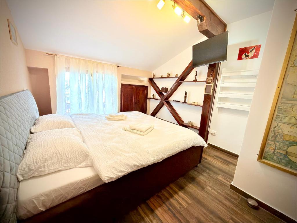 a bedroom with a large bed with a window at La Mansardă in Câmpulung