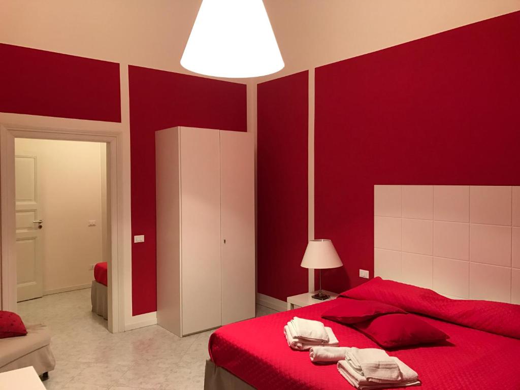 トラーパニにあるAlbaChiara Suite Rooms - City Centerの赤い壁のベッドルーム1室(赤いベッド1台付)