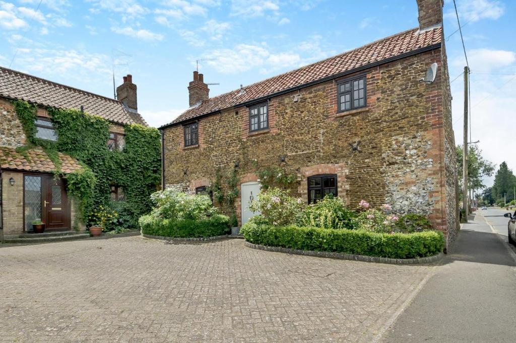 an old brick building with flowers in front of it at 2 Bed in Grimston oc-1622 in Grimston