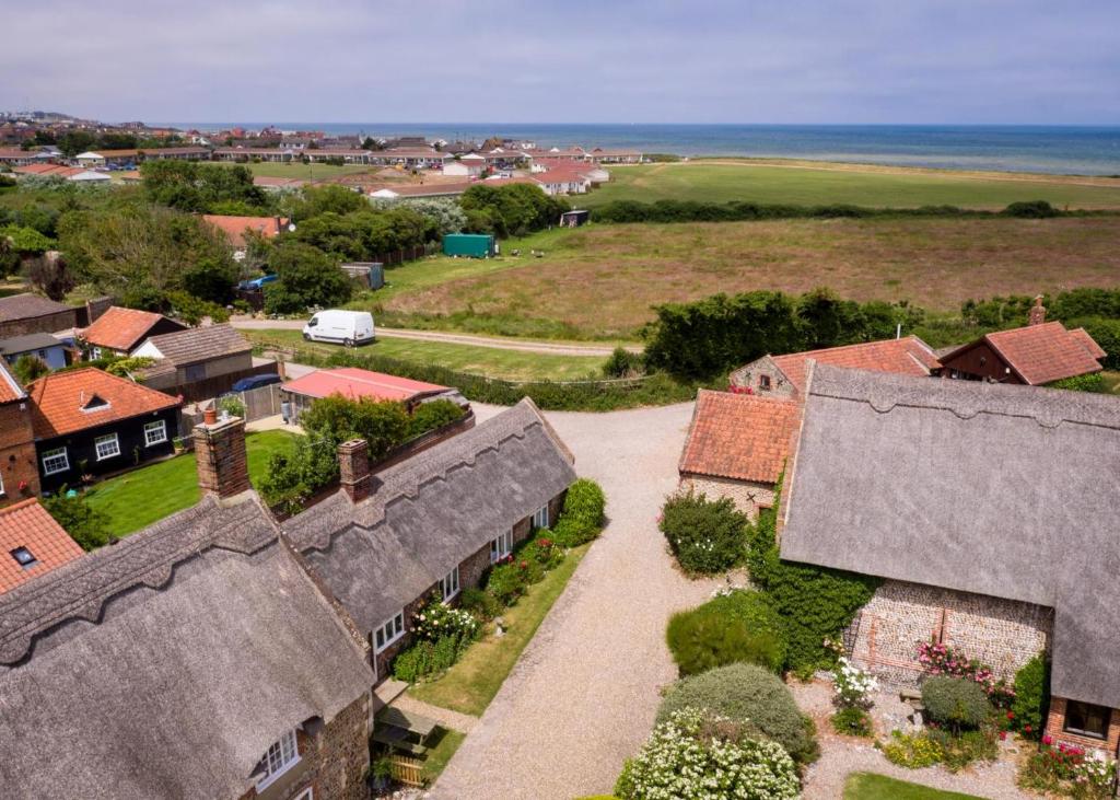 an aerial view of a village with houses and the ocean at 2 Bed in Bacton oc-710 in Bacton