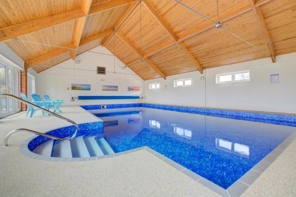 a large swimming pool with blue tiles on the ceiling at 2 Bed in Roughton oc-1626 in Roughton