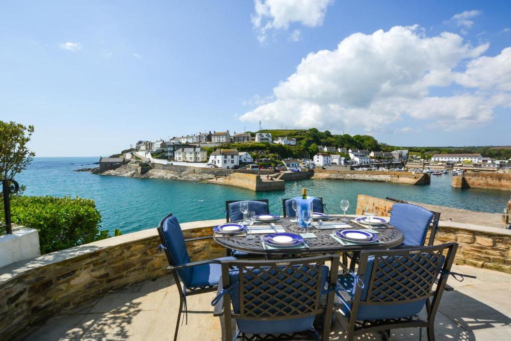 a table and chairs on a balcony with a view of the water at 3 Bed in Porthleven oc-7bayvi in Porthleven