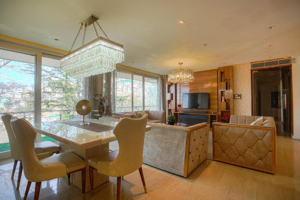 a kitchen and living room with a table and chairs at Samar Villa BnB in Shimla