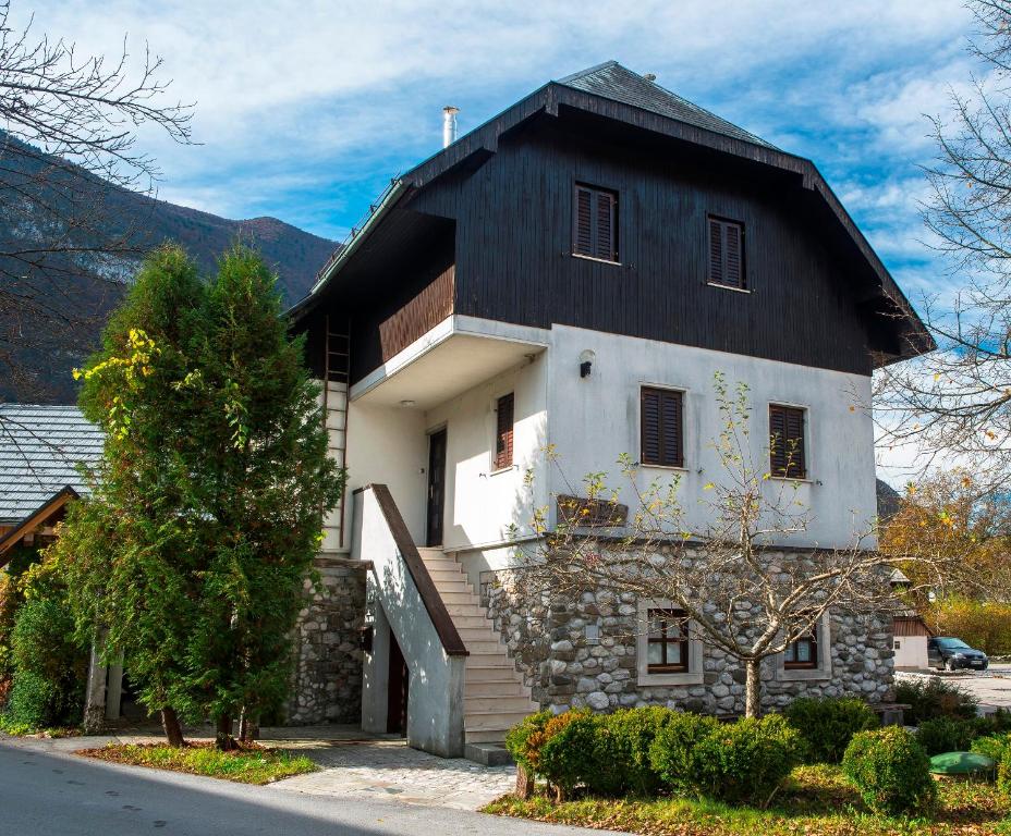 uma casa branca e preta com um telhado preto em Guest house Vila Korošec em Bovec