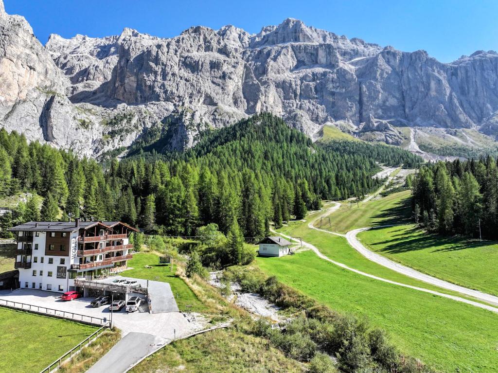 una vista aerea di un resort con le montagne sullo sfondo di Hotel Wolf a Selva di Val Gardena