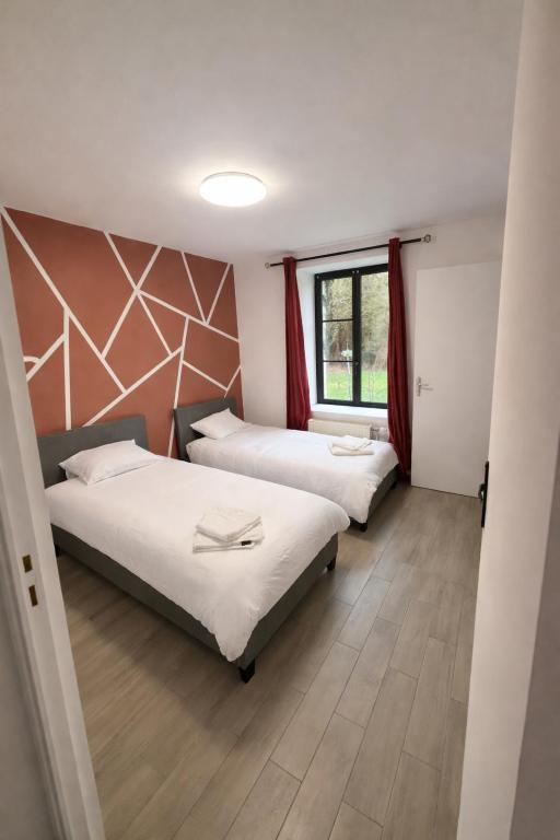 a room with two beds and a window at Gîtes de la Renaissance in Merlieux-et-Fouquerolles