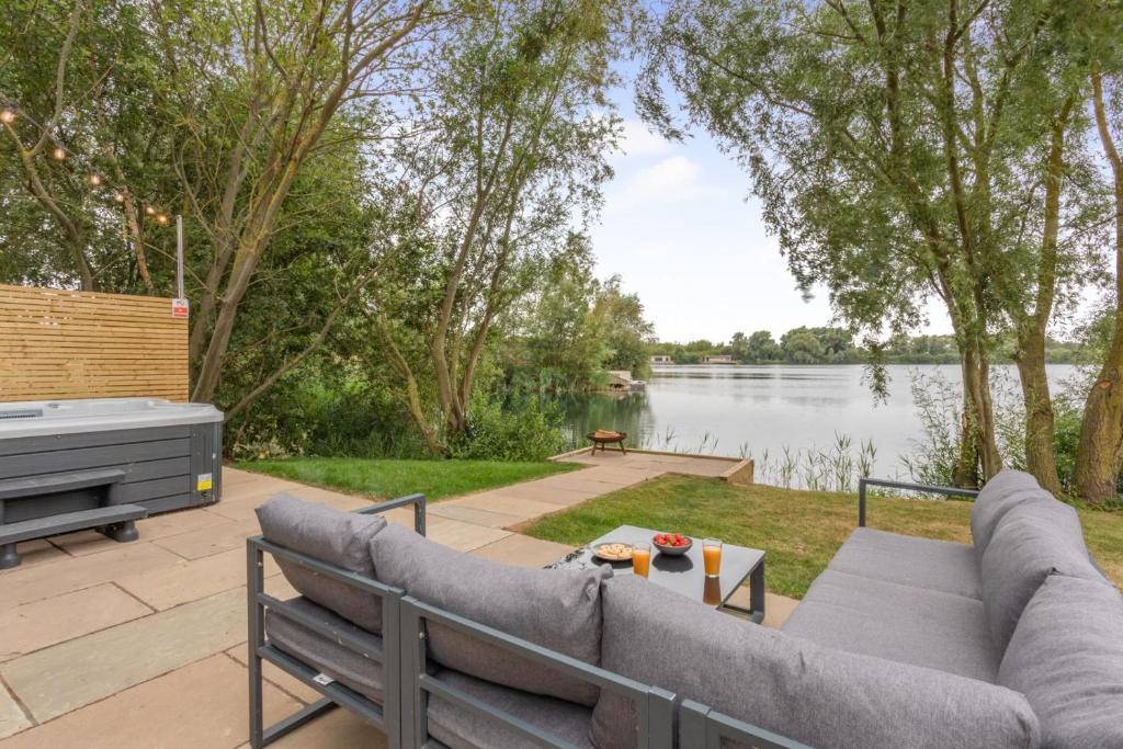 a patio with a couch and a tv and a lake at 1 Bed in Langtoft oc-l32679 in Langtoft