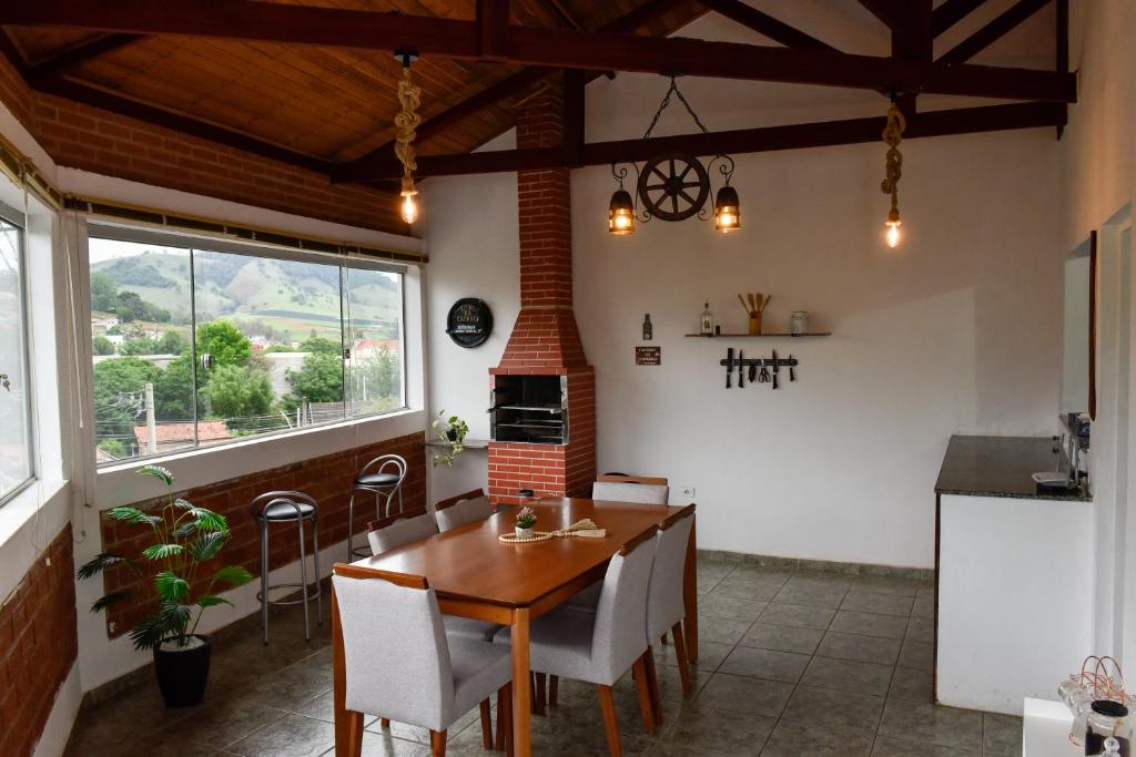 a kitchen with a table and chairs in a room at Paraiso Mantiqueira in Paraisópolis