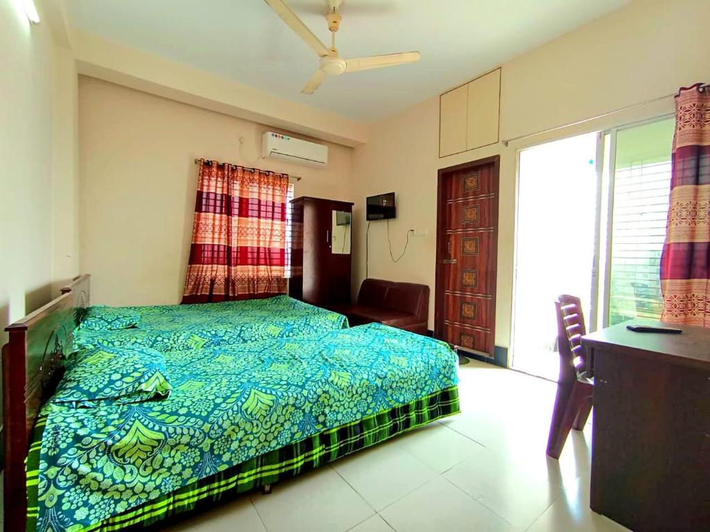 a bedroom with a bed with a blue comforter at Hotel Relax Residential in Khulna