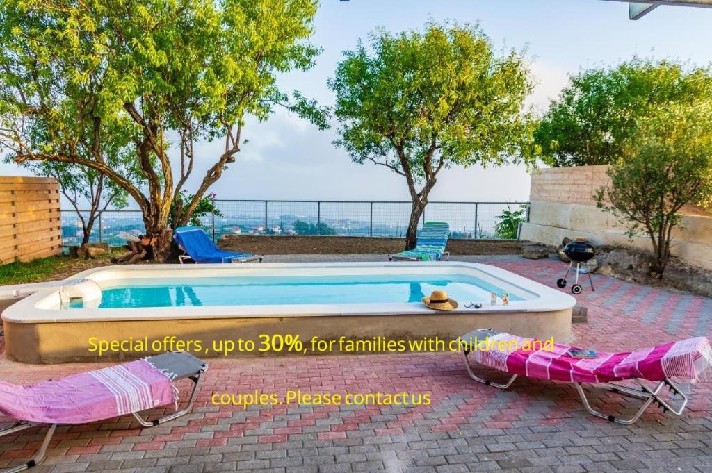 a swimming pool with two lawn chairs next to it at Le Paradis d' Elli in Lakíthra