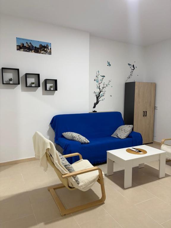 a living room with a blue couch and a coffee table at Casa 22 in Plasencia