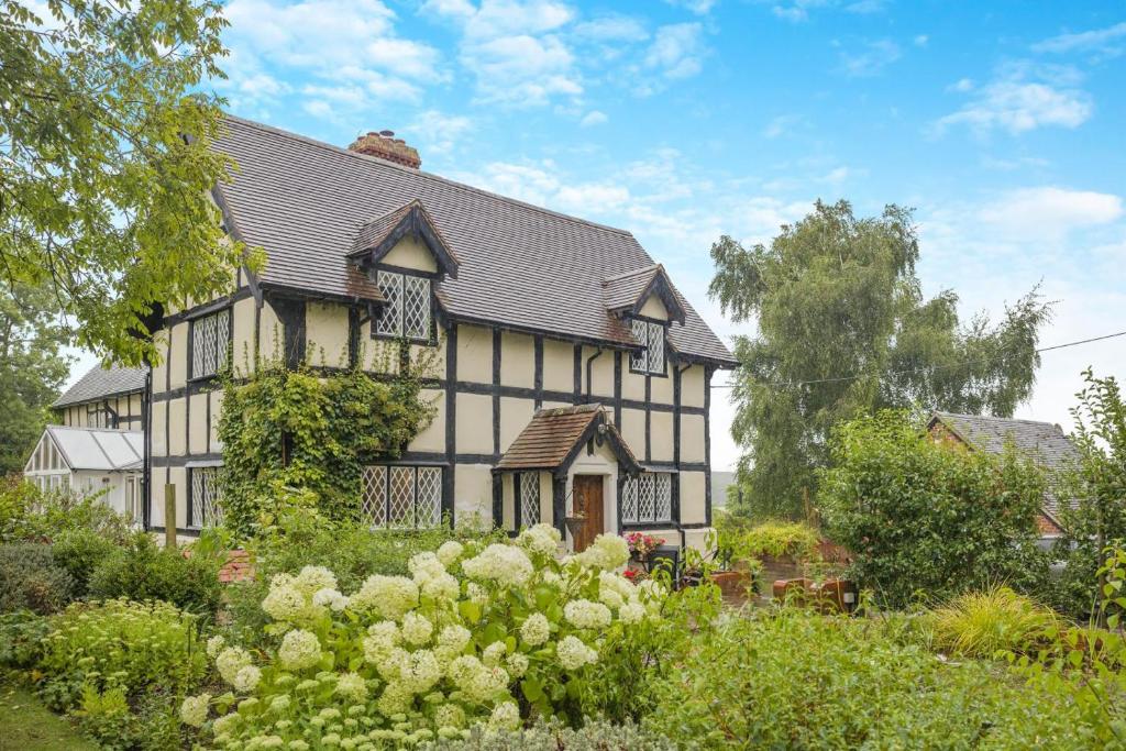 a black and white house with flowers in front of it at 2 Bed in Woofferton oc-b29941 in Woofferton