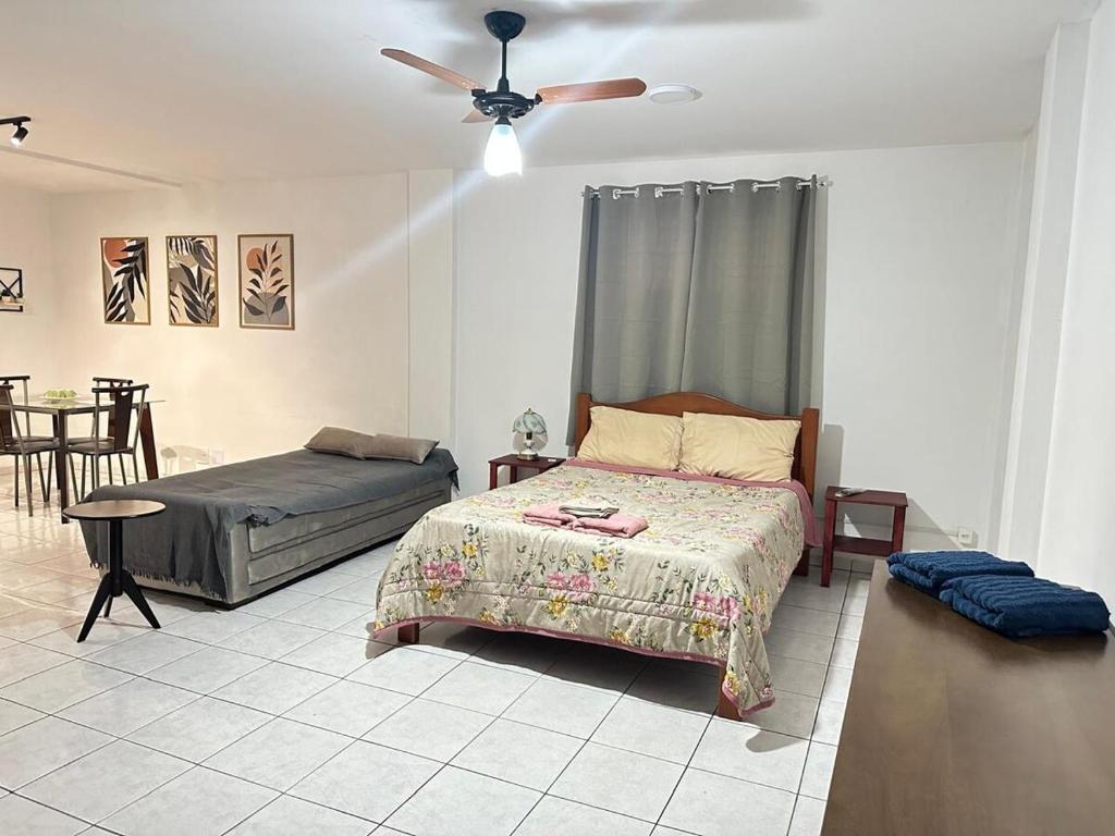 a bedroom with a bed and a ceiling fan at Loft Studio Central in Nova Friburgo