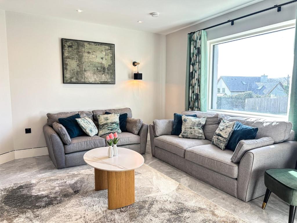 a living room with two couches and a table at Central Haven Dingle in Dingle