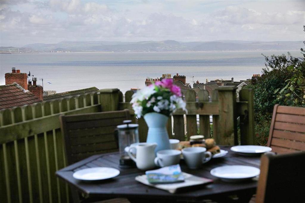 a table with a vase of flowers on top of a balcony at 3 Bed in Mumbles oc-hh19 in The Mumbles