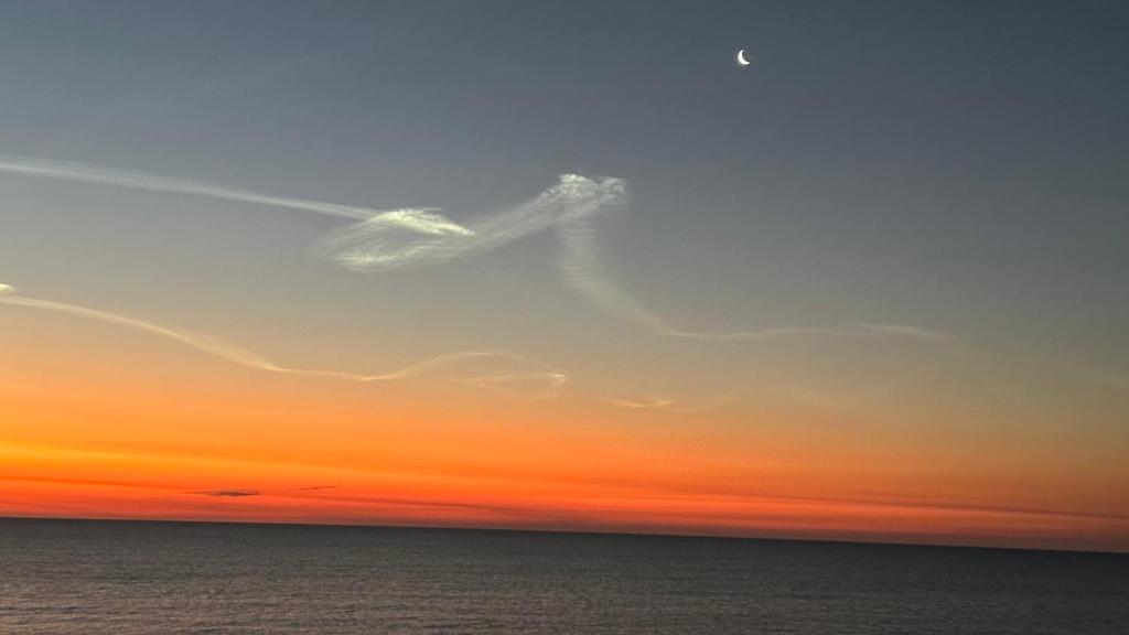 a cloud in the sky over the ocean at sunset at Beach Skybox HHI in Hilton Head Island