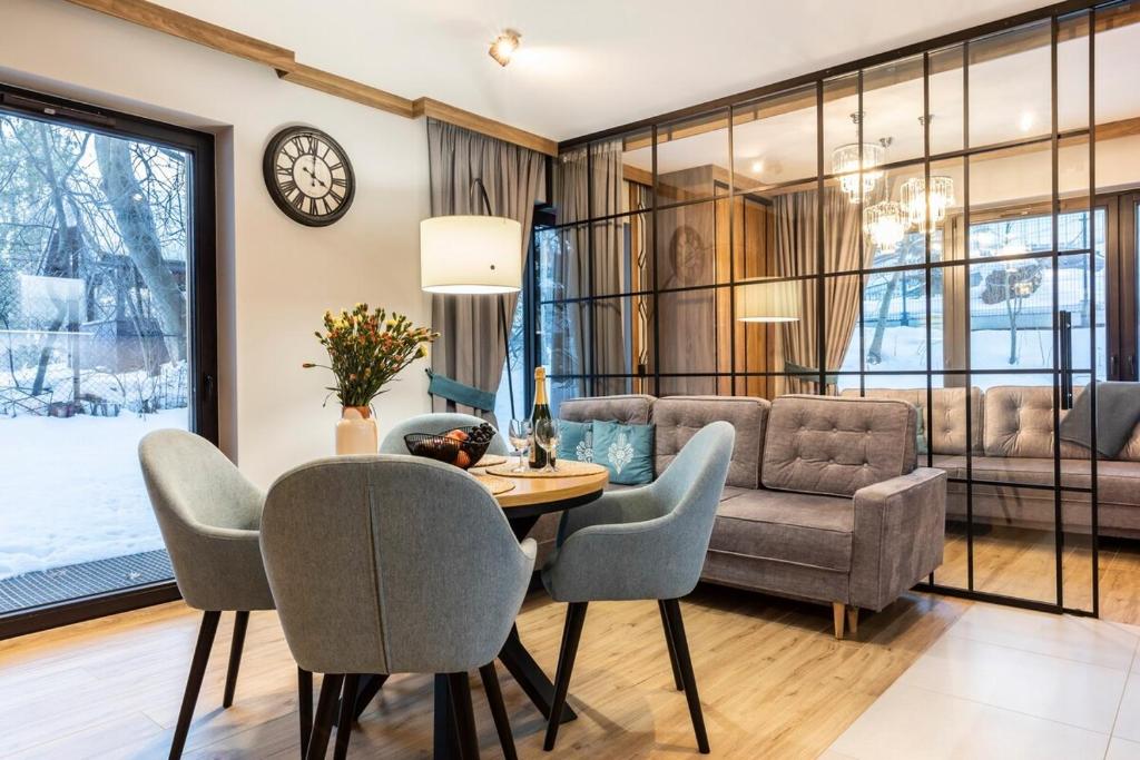 a living room with a table and chairs and a couch at Czerwone Wierchy Premium Apartment in Zakopane