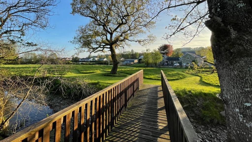 a wooden bridge over a river with a tree at 1 Bed in Drefach oc-m30848 in Llanwenog