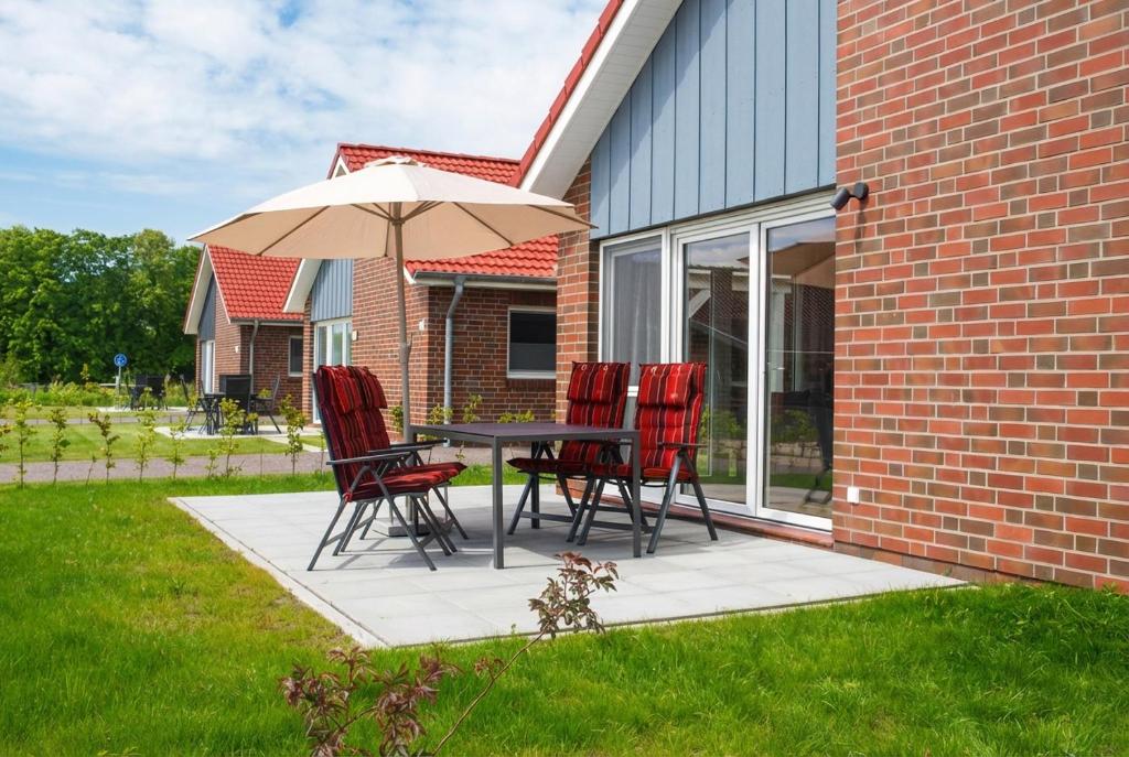 a table and chairs with an umbrella on a patio at Haus Dornröschen in Schweiburg