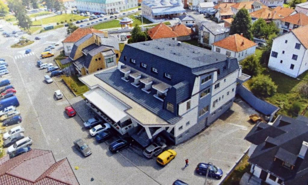 a large building with a parking lot in a city at Hotel Lane in Sjenica