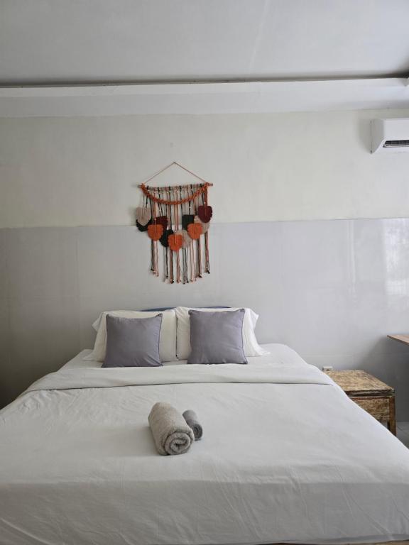 a white bed with a stuffed animal on top of it at Rumah Risa in Tanah Lot