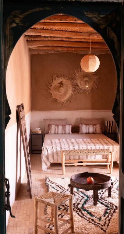 a bedroom with a bed and a table in a room at Muma Lodge in Bouihat