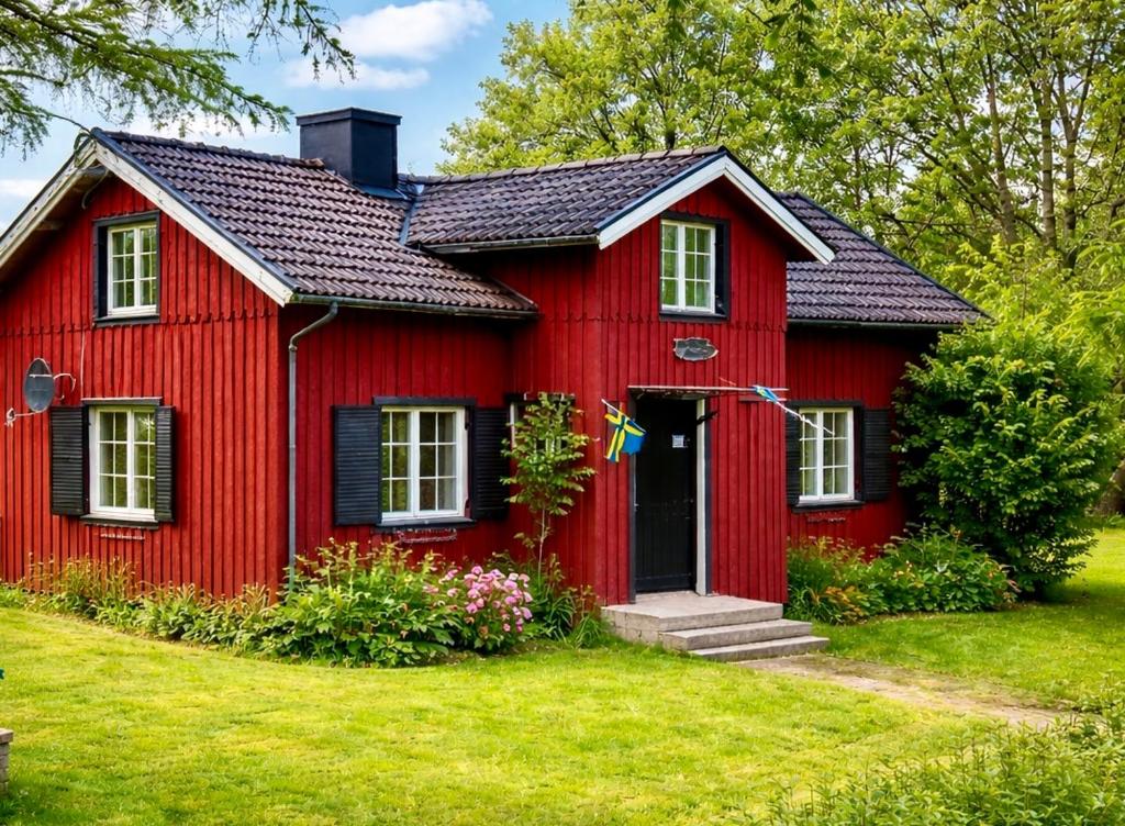 a red house with a black roof at Lilla Röda Huset. in Sjötofta