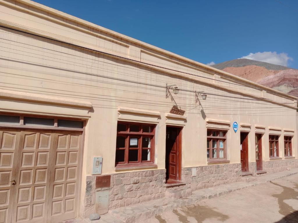 a white building with brown doors and windows at MiskyPacha in Purmamarca