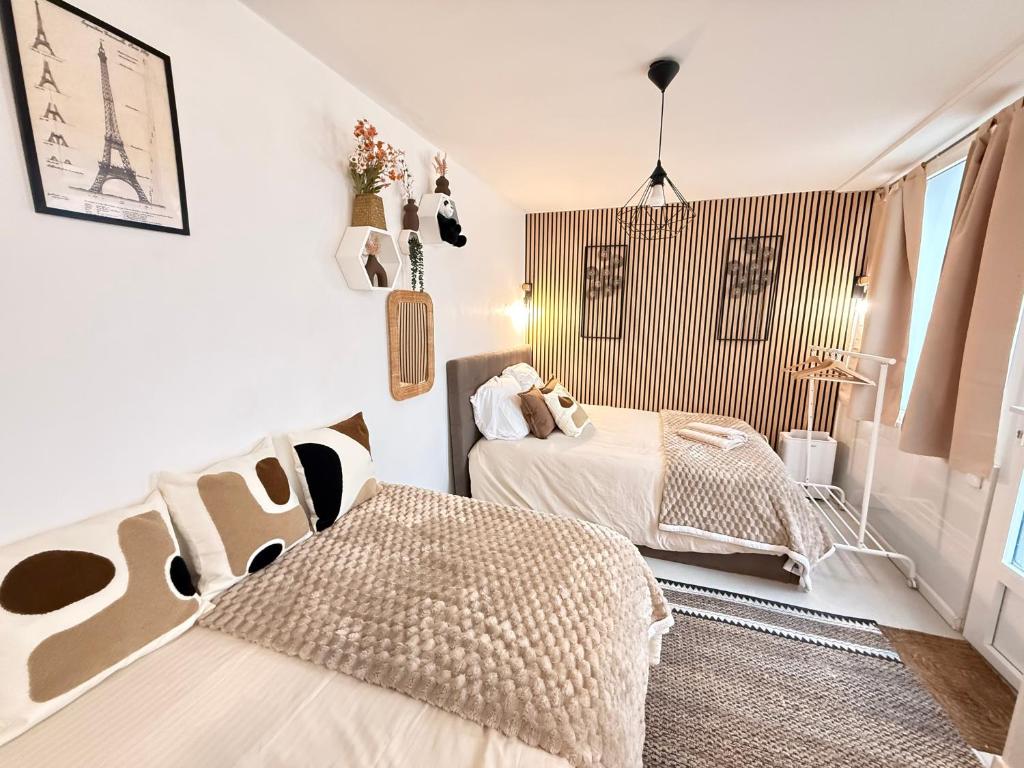 two beds in a room with white walls at BEAUTY SAINT PAUL renovated February 2026 in Paris