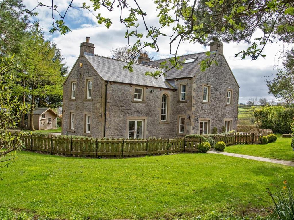 an old stone house with a wooden fence at 7 Bed in Buxton oc-93808 in Tideswell