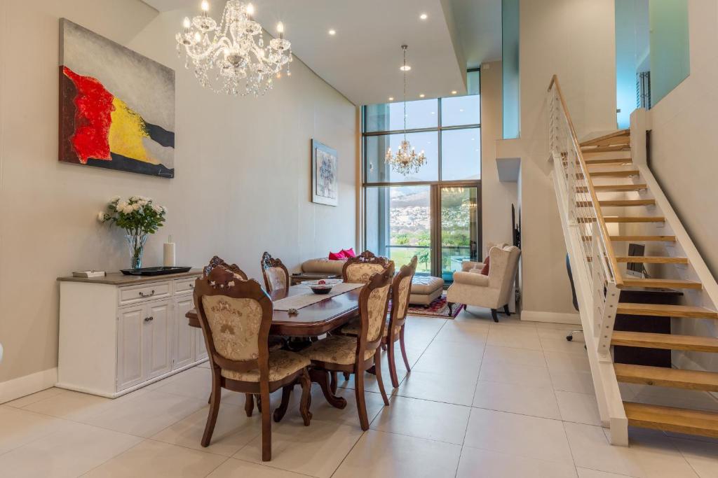 a kitchen and dining room with a table and chairs at V&A Waterfront Luxury by Nivar in Cape Town