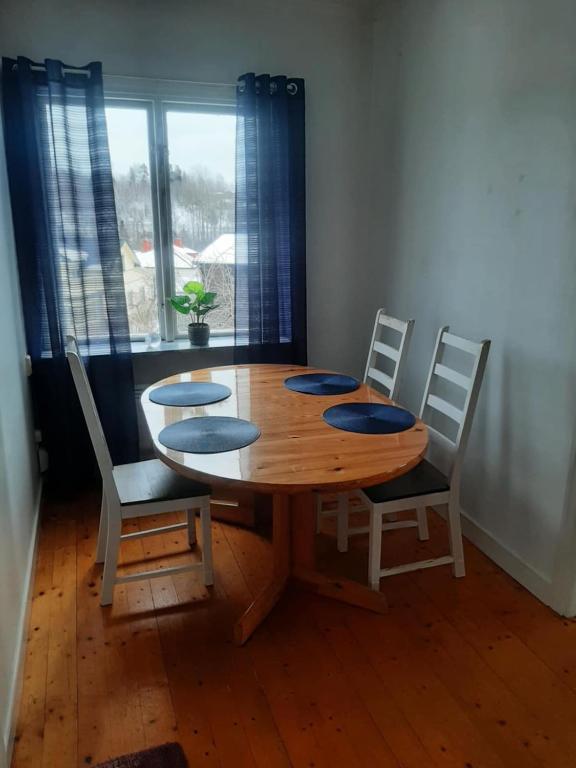 a wooden table and chairs in a room with a window at Nära lasarettet i Lindesberg in Lindesberg