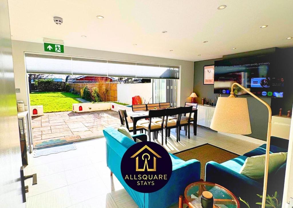 a living room with a blue couch and a dining room at The Lockside By Allsquare Stays 5BDR Heathrow M4 M25 M3 in Staines
