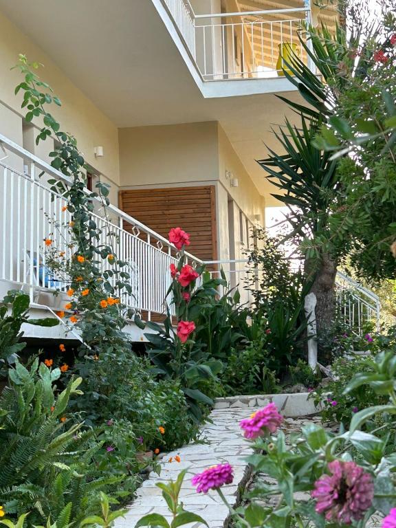 a garden with flowers in front of a house at Nikos & Vivi Studios in Perivólion
